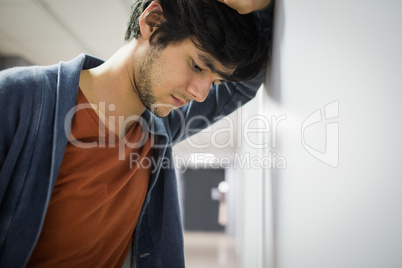 Worried student leaning on wall