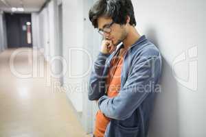 Worried student leaning on wall