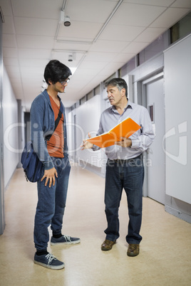 Professor with notebook talking to a student