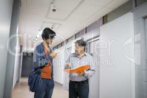 Professor with notebook talking to a student