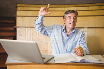 Confident professor raising his hand in classroom