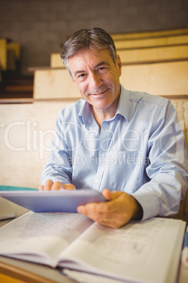 Professor sitting at desk using digital tablet