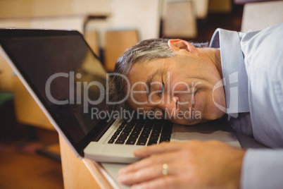Professor sleeping on his laptop at desk