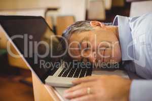 Professor sleeping on his laptop at desk