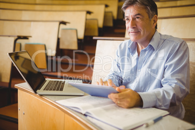 Thoughtful professor using digital tablet