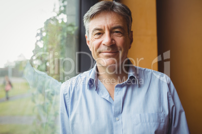 Portrait of professor standing near window