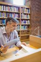Professor holding digital tablet and reading book