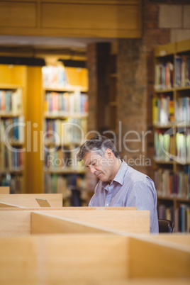 Professor sitting on desk using his laptop