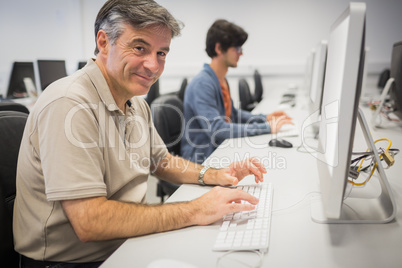Portrait of happy professor working on computer