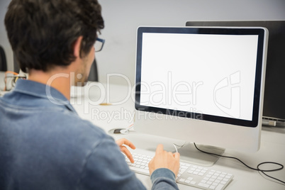 Rear view of student using computer