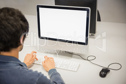 Rear view of student using computer