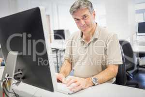 Portrait of happy professor working on computer