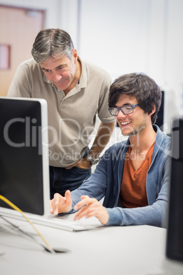 Computer teacher assisting a student