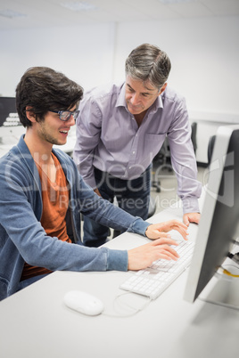 Computer teacher assisting a student