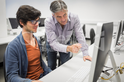 Computer teacher assisting a student