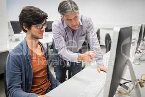 Computer teacher assisting a student