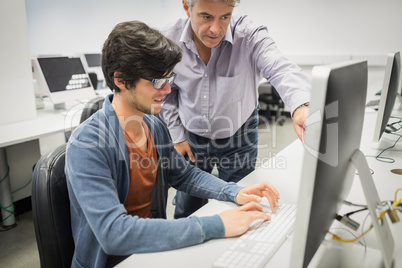 Computer teacher assisting a student