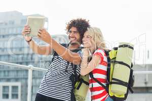 Young couple taking a selfie with digital tablet