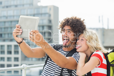 Young couple taking a selfie with digital tablet