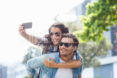 Man giving piggyback to woman