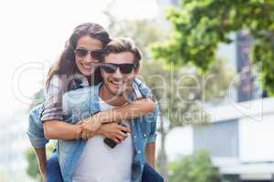 Man giving piggyback to woman