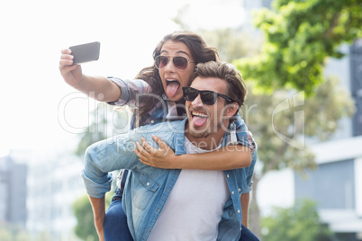 Man giving piggyback to woman