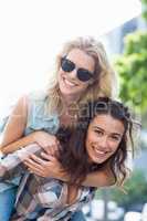 Woman giving piggyback to her friend