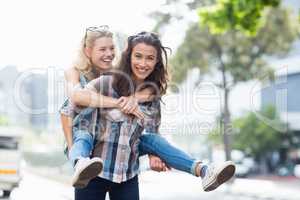 Woman giving piggyback to her friend