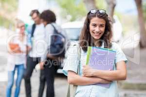 Portrait of young woman holding books