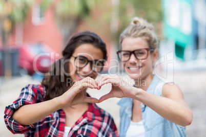 Friends making heart shape with hands