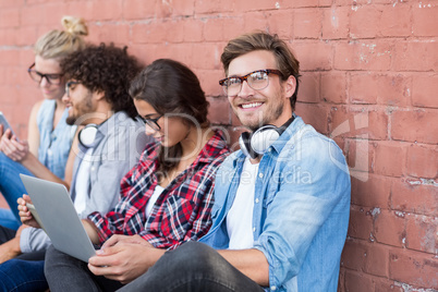 Friends sitting against wall