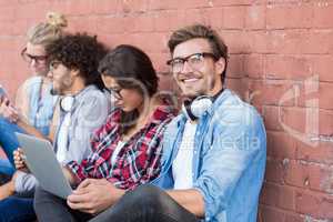 Friends sitting against wall