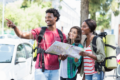 Friends holding map and pointing