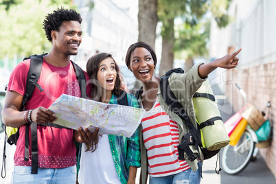 Friends holding map and pointing