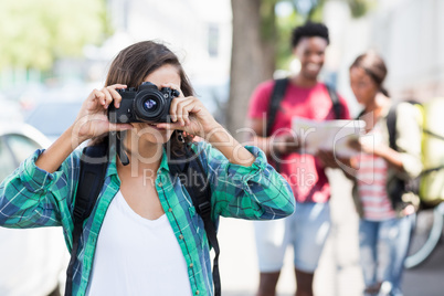 Woman wearing backpack taking photo