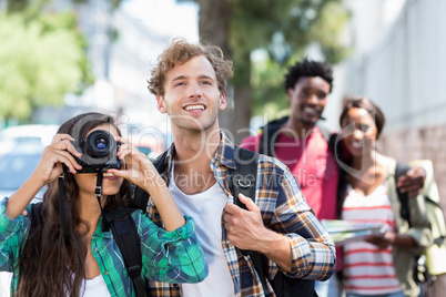 Woman standing with man taking photo