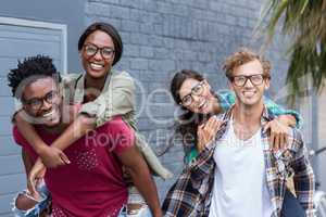 Young men giving piggyback to women