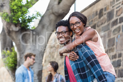 Young man giving piggyback to woman