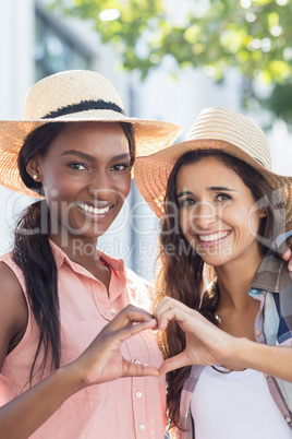 Friends making heart shape with hands