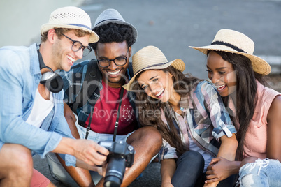 Man showing photos in camera to his friends