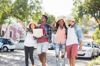 Friends holding map and pointing