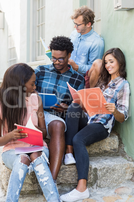 Friends sitting together and reading book