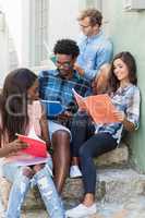 Friends sitting together and reading book