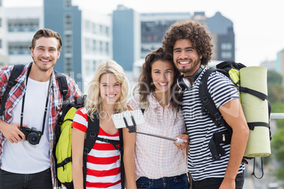 Group of friends taking selfie with selfie stick