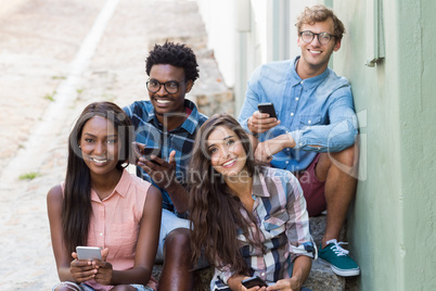 Friends sitting together using mobile phone