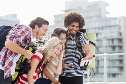 Group of friends taking selfie with selfie stick