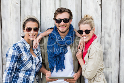 Friends in sunglasses using digital tablet