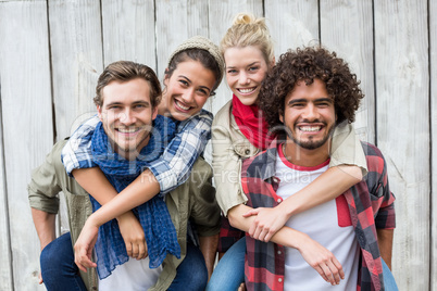 Young men giving piggyback to women