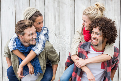 Young men giving piggyback to women