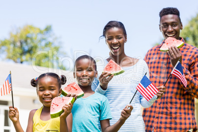 Happy family eating watermelon and showing usa flag